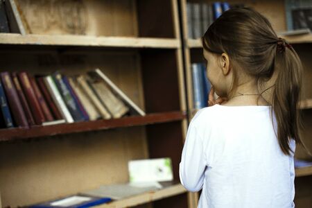 Little girl choosing books at street library