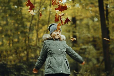 Child with autumn leaves. Autumn outdoor portrait. Happy little girl in autumn forest. Autumn leaves and nature.の写真素材