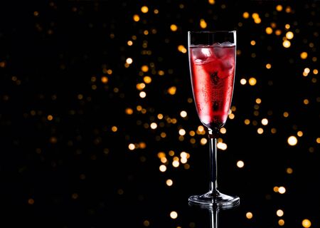 Glass of red champagne with ice on black backgroundの写真素材