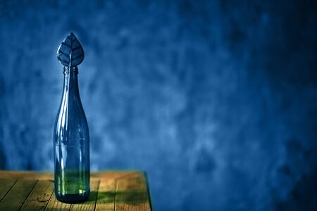 Glass blue empty bottle on dark background with candyの写真素材
