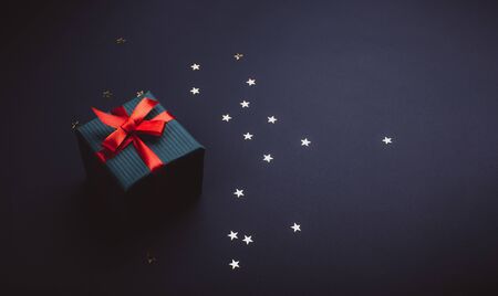 Gift bandaged with red ribbon on a black backgroundの写真素材