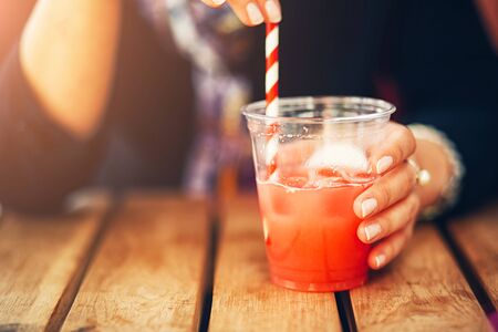 Refreshing ice cold water, woman at the bar drinks fresh cold watermelon juiceの写真素材