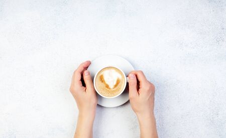 Hand holding one cup of coffee on white color backgroundの写真素材