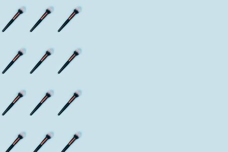 Cosmetic makeup brush on blue color background, top view patternの写真素材