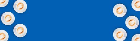 Cup with latte pattern on blue color background, flat lay top viewの写真素材