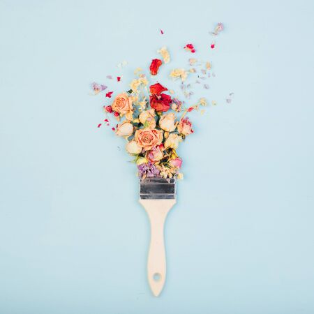 Brush paints with flowers, spring concept on pastel blue background. Minimal nature flat lay.の写真素材