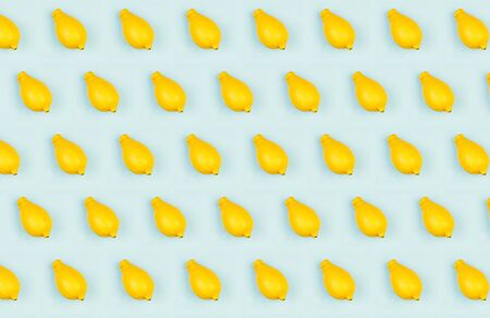 Fresh lemons pattern a blue background flat lay, concept of healthy eating, raw food diet and vegetarianismの写真素材
