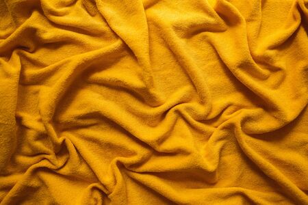 Yellow background made of fabric, the concept of heat and home comfort