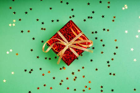 Gift and stars on green background, new year concept