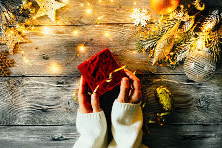 Woman's hands holding gift box. Christmas background with gift boxesの写真素材