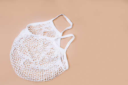 Reusable shopping bag on blue background, top view of mesh shopping cotton bag. Ecological concept.