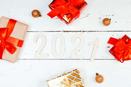 2021 figures New Year and gifts on withe wooden background