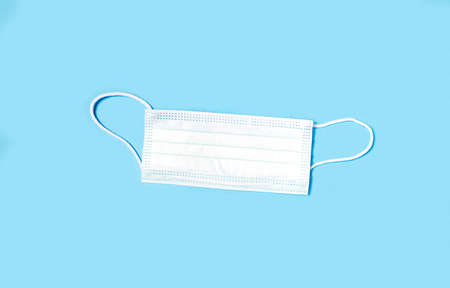 Medical mask on a blue background, view from above