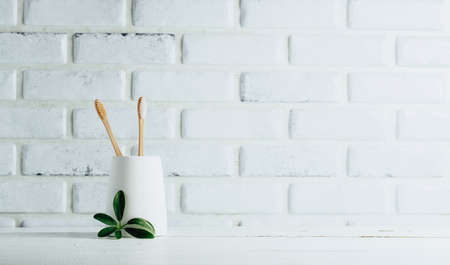 Two bamboo toothbrushes in a glass, minimalistic style in the bathroom, dental careの写真素材