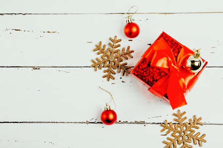 Red box gift with red ribbon in New Year's balls and shiny snowflakes, top viewの写真素材