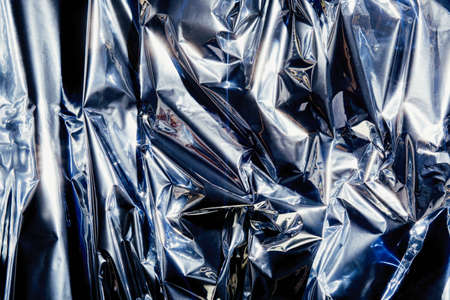 Foil background with shiny crumpled surface for texture backgroundの写真素材