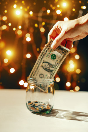Woman's hand takes money from a piggy bank for new year giftsの写真素材