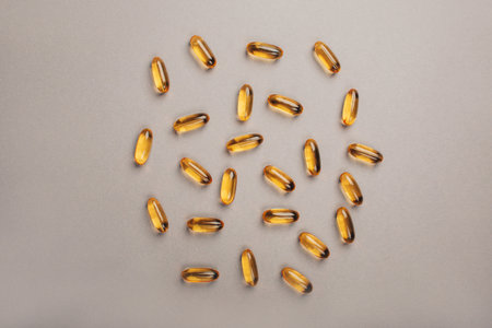 Transparent vitamins yellow on a gray background, flat layの写真素材
