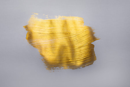 Golden paint on a gray background with a brush, New Year 2021 concept