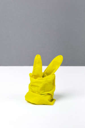 The concept of Easter pandemic with yellow glove on gray and withe backgroundの写真素材