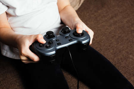 Girl plays on the console, close-up portraitの写真素材