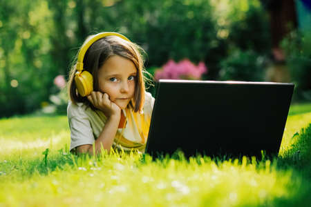 The girl behind the computer in nature, remote learningの写真素材