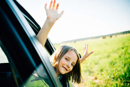 Girl travels in a car, looks out of the window, summer holiday conceptの写真素材