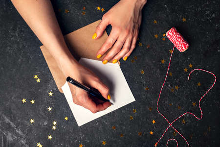 A woman writes plans for 2022 on black background top viewの写真素材