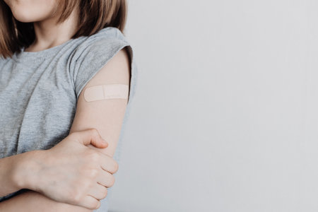 The girl was vaccinated in her arm, a plaster on her armの写真素材