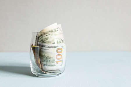 Bills in a glass jar, saving and saving money during the economic crisisの写真素材