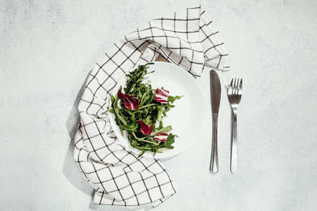 White plate with salad and towel on background top view, healthy fresh hedgehog rich in vitaminsの写真素材