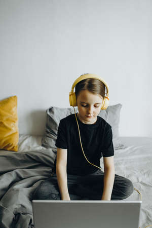 A girl studies at a laptop at home In the bedの写真素材