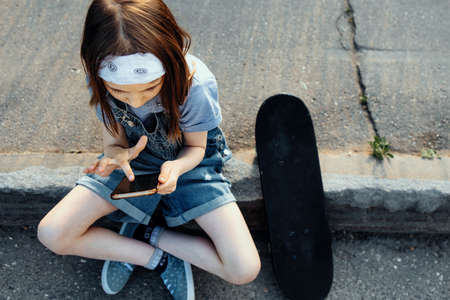 A girl learns to ride a skateboard in the parkの写真素材