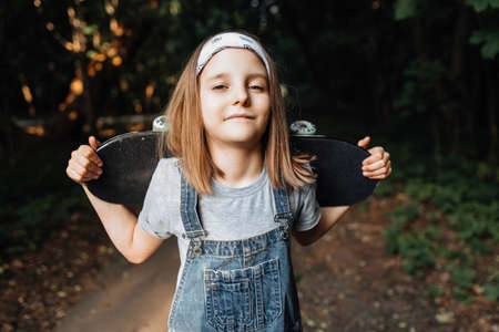A girl learns to ride a skateboard in the parkの写真素材