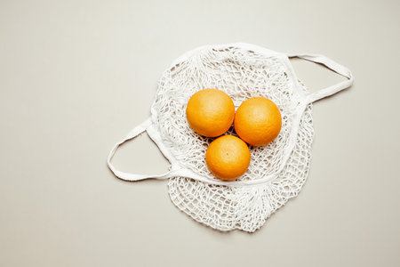 Fruits in a mesh bag on background top viewの写真素材