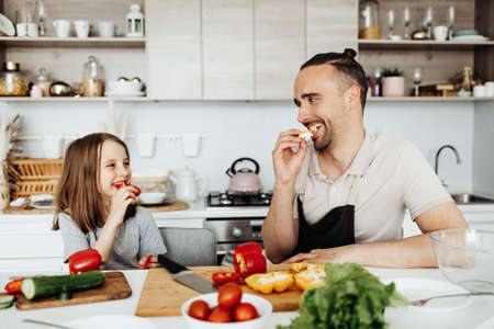 Dad and daughter cook a salad together, joint weekends and funの写真素材
