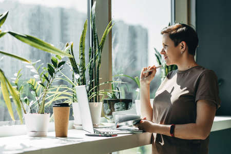 A woman works remotely from a cafe, cozy space for working outside the office
