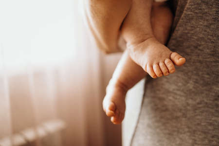 Mom holds baby in her arms, back viewの写真素材