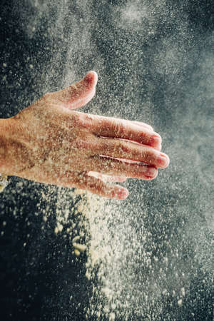 Child preparing pizza dough and clapping flour with hands, home food concept