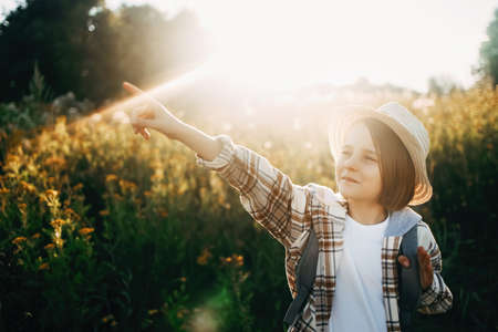 Young traveler hiking girl with backpacks. Sunny landscape and tourist travelerの写真素材