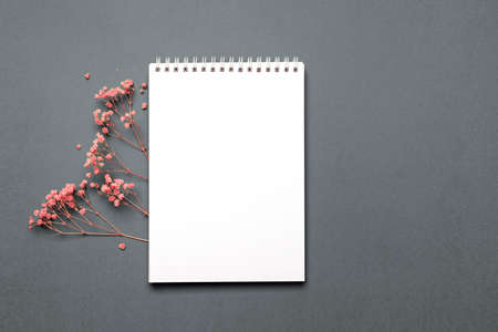 Notebook with pink flowers on gray background, top view