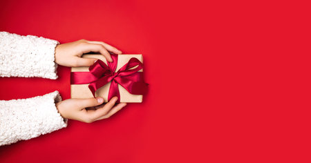 Baby hand holds gift view from above, holiday conceptの写真素材
