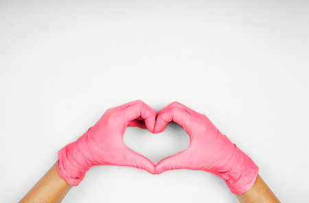Hands in viva magenta color heart-shaped medecine gloves concept 2023の写真素材