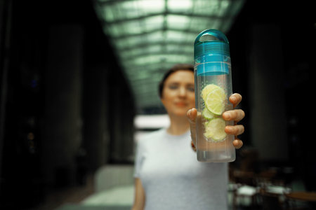 A young woman with cold drink in city, outdoors in the summer in the city centerの写真素材