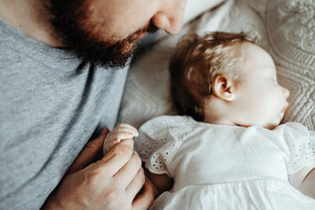 Baby sleeps with daddy on the bed