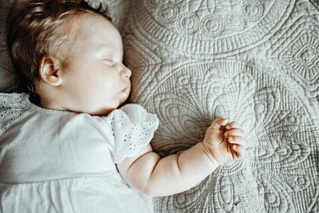 A newborn baby sleeps sweetly on a quilt, a calm daytime sleep of a newborn babyの写真素材