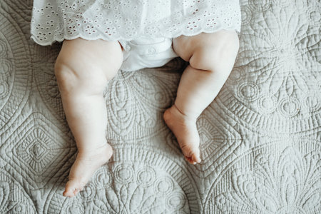 Legs of big baby sleeping on the bedの写真素材