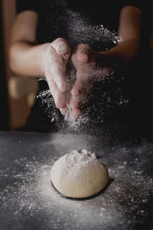 flour and dough in hands of a personの写真素材