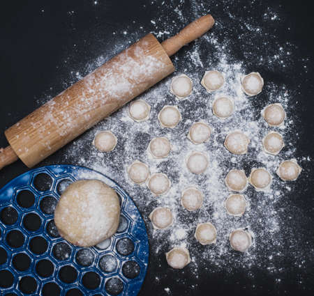 homemade dumplings sprinkled with flour on a black background, food photoの写真素材