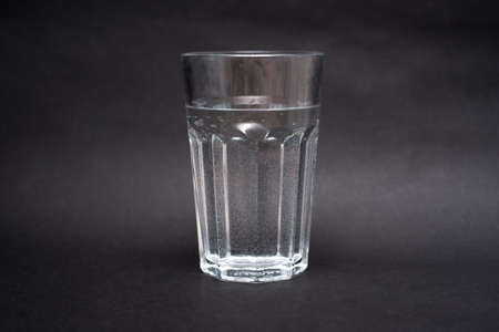 transparent glass of water on black